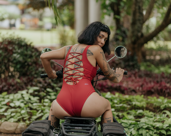 Bodysuit in lighter red - motorcycle pose